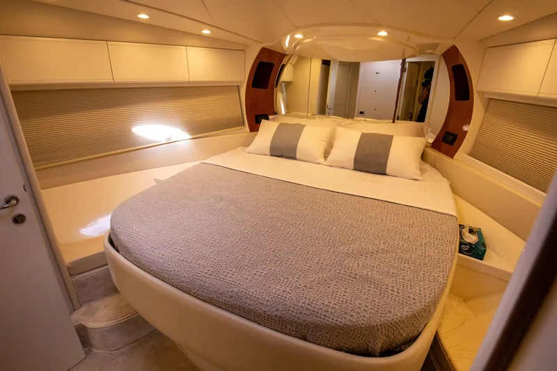  Yacht Photos Pics Luxurious bedroom interior of a 2002 Pershing 52 yacht with elegant bedding and ambient lighting.