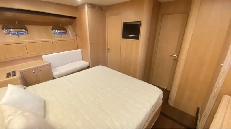  Yacht Photos Pics Luxurious 2008 Mangusta 72 yacht bedroom with modern wood interior and comfortable bedding.
