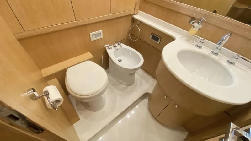  Yacht Photos Pics Luxurious bathroom in 2008 Mangusta 72 yacht with modern fixtures and wooden cabinetry.