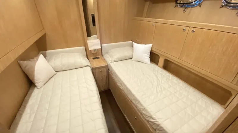  Yacht Photos Pics Twin cabin interior of 2008 Mangusta 72 yacht with wooden furnishings and white bedding.