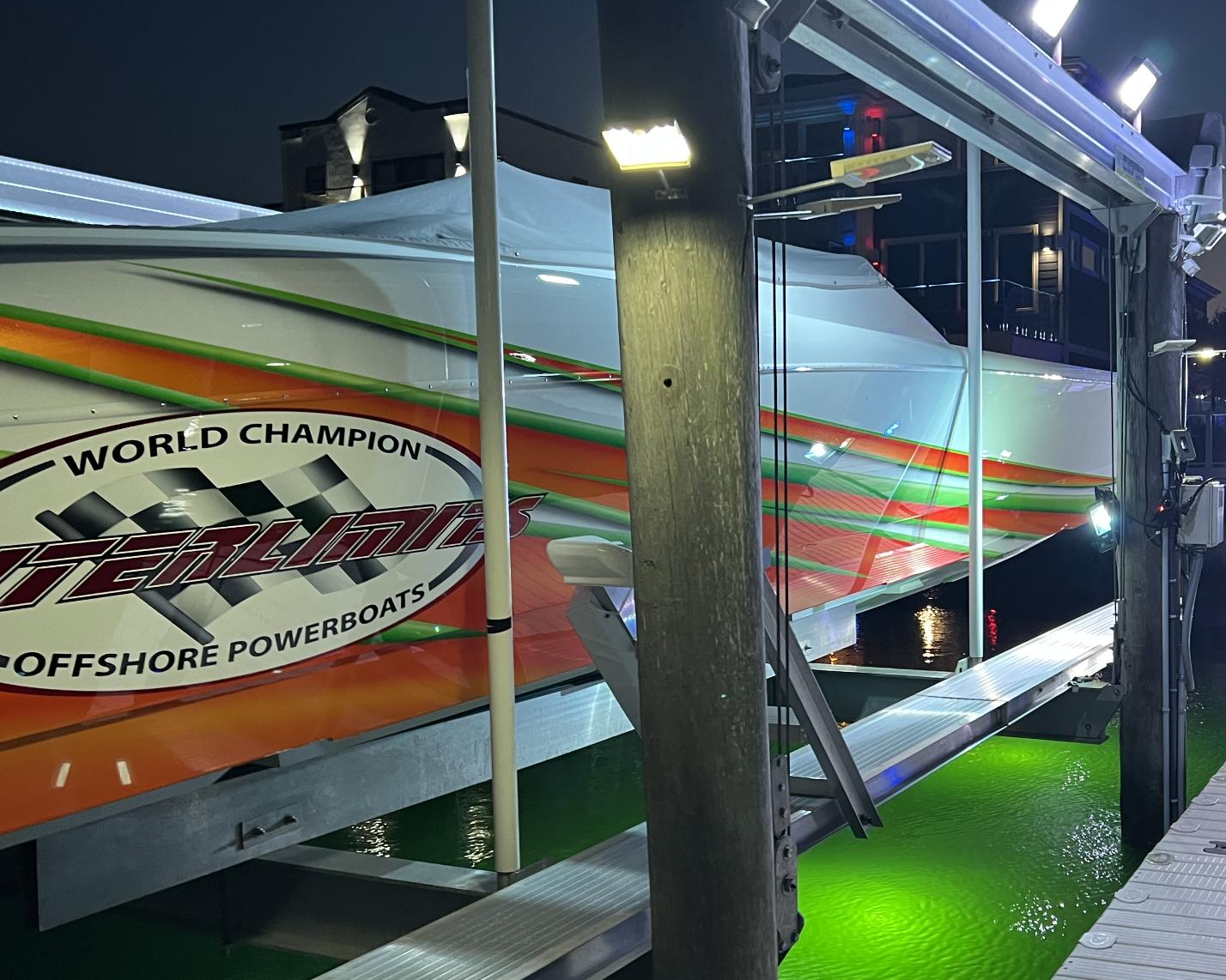 2015 Outerlimits SL-50 offshore powerboat on a lift at night.