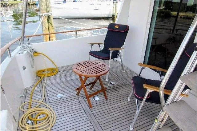 Aquavit Yacht Photos Pics 2006 Beneteau Swift Trawler 42 deck with chairs and table, docked by water.