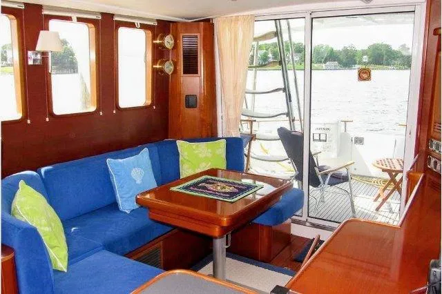 Aquavit Yacht Photos Pics Interior of 2006 Beneteau Swift Trawler 42 with blue seating and wooden table.