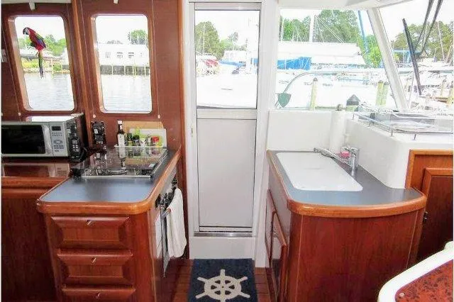 Aquavit Yacht Photos Pics Interior of 2006 Beneteau Swift Trawler 42, featuring a compact kitchen with wood cabinetry.