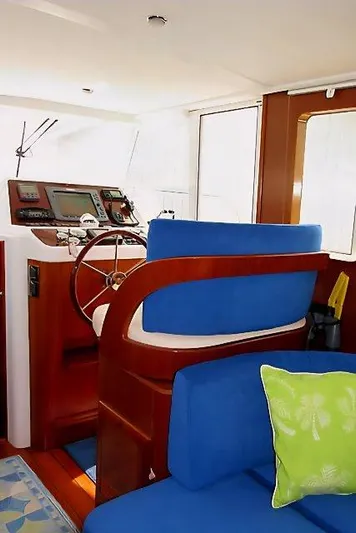 Aquavit Yacht Photos Pics 2006 Beneteau Swift Trawler 42 interior with helm, blue seating, and wooden accents.