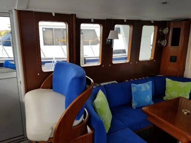 Aquavit Yacht Photos Pics Interior of 2006 Beneteau Swift Trawler 42 with blue seating and wooden accents.