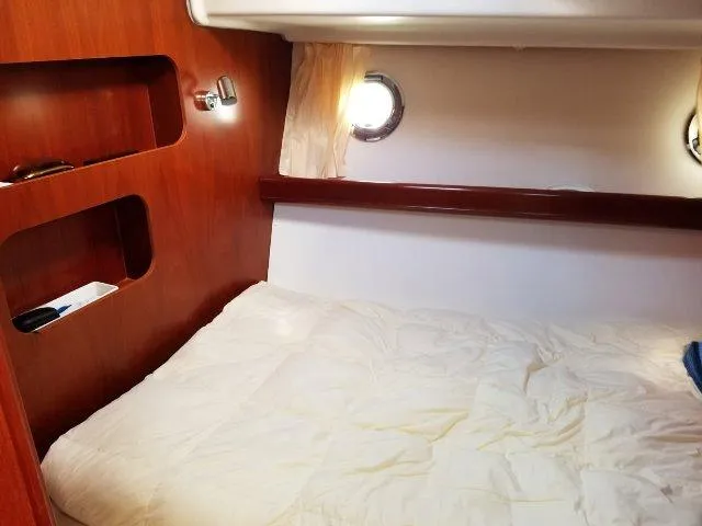 Aquavit Yacht Photos Pics Cozy cabin interior of 2006 Beneteau Swift Trawler 42 with wooden shelves and porthole.