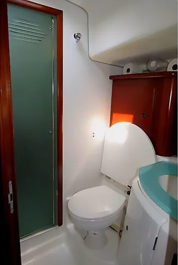 Aquavit Yacht Photos Pics 2006 Beneteau Swift Trawler 42 bathroom with shower, toilet, and wooden cabinetry.