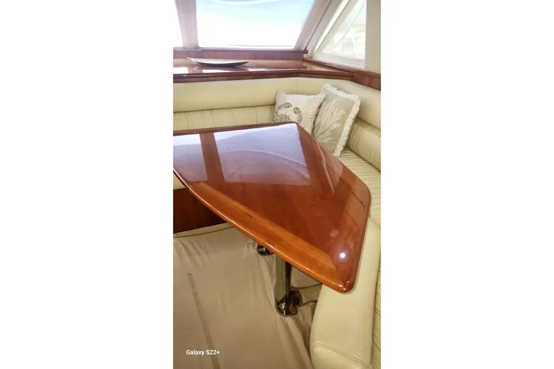 Last Dance Yacht Photos Pics Luxurious interior of 2006 Riviera 47 Open Flybridge Series II with polished wooden table.