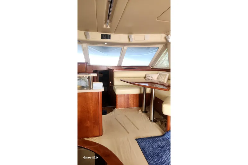 Last Dance Yacht Photos Pics Luxurious interior of 2006 Riviera 47 Open Flybridge Series II yacht with elegant seating and table.