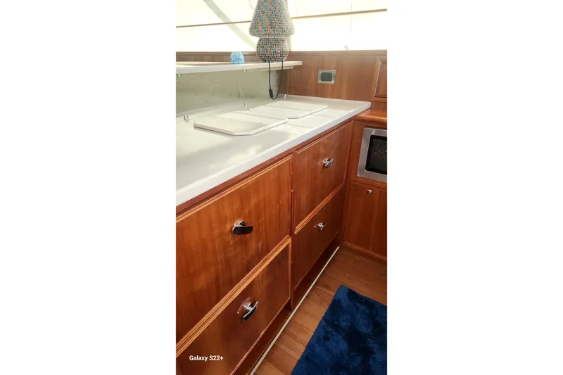 Last Dance Yacht Photos Pics 2006 Riviera 47 Open Flybridge Series II yacht kitchen with wooden cabinets and countertop.