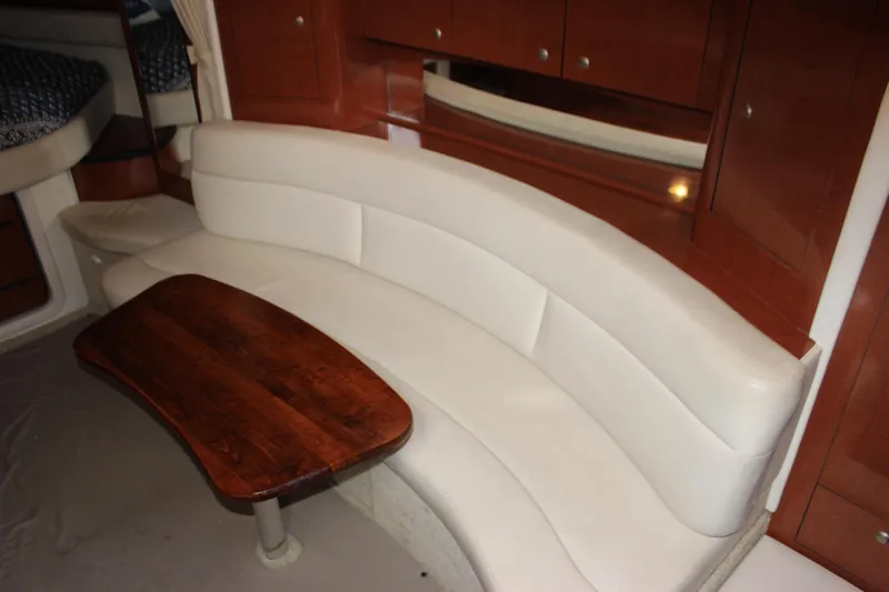  Yacht Photos Pics 2005 Sea Ray 340 Sundancer interior with curved white leather seating and wooden table.