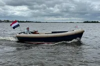 Interboat 21 Classic motorboat cruising on a lake under cloudy skies, 2000 model.