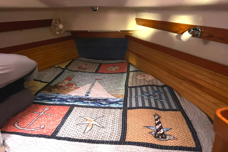  Yacht Photos Pics Cozy cabin interior of 2009 Catalina 375 sailboat with nautical-themed quilt.