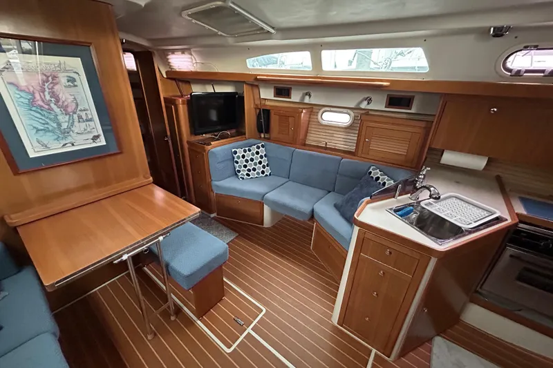  Yacht Photos Pics Interior of 2009 Catalina 375 sailboat with cozy seating, kitchenette, and wooden finishes.