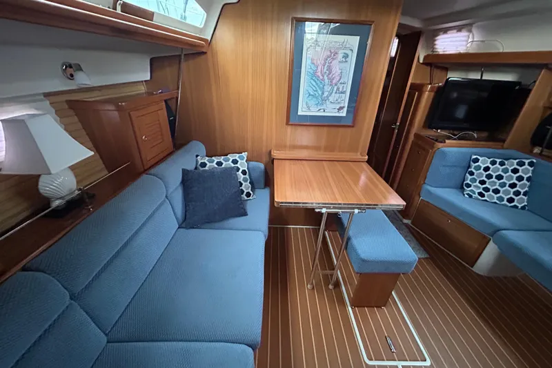  Yacht Photos Pics Interior of 2009 Catalina 375 sailboat with blue seating, wooden table, and nautical decor.