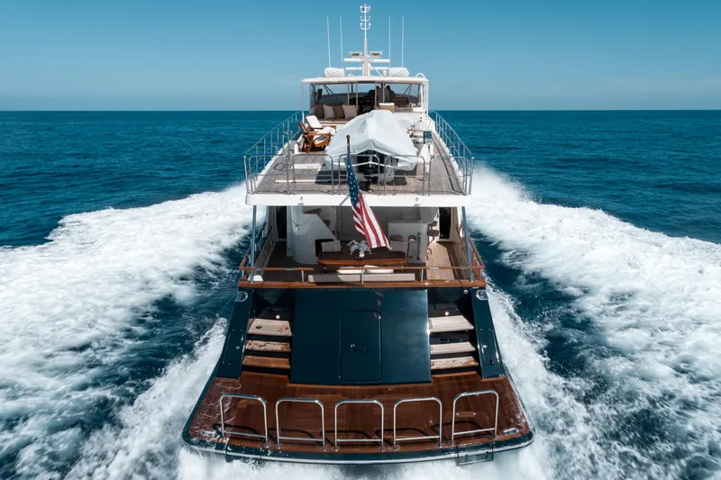 Rat Pack Yacht Photos Pics 2011 Marlow Explorer yacht cruising on open sea, rear view with American flag.