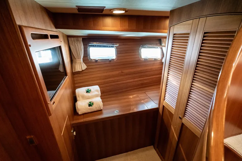 Rat Pack Yacht Photos Pics Luxurious wooden interior of 2011 Marlow Explorer yacht cabin with portholes and towels.
