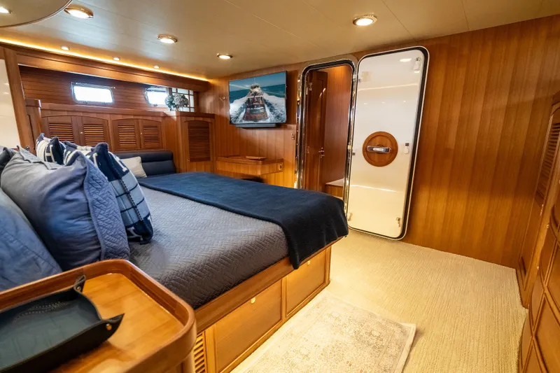 Rat Pack Yacht Photos Pics Luxurious cabin interior of 2011 Marlow Explorer yacht with wooden paneling and cozy bedding.