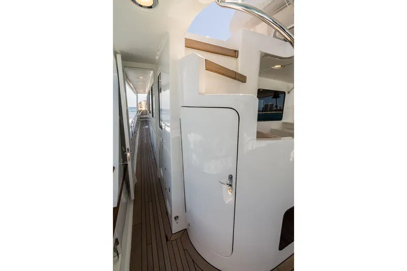 Rat Pack Yacht Photos Pics Side deck view of 2011 Marlow Explorer yacht with sleek white finish and wooden flooring.