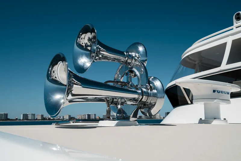 Rat Pack Yacht Photos Pics Chrome horns on 2011 Marlow Explorer yacht against clear blue sky.