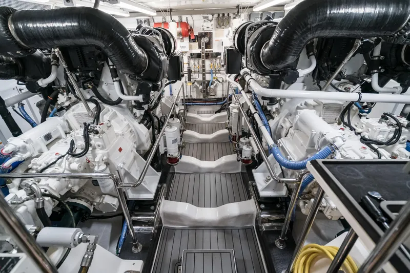 Rat Pack Yacht Photos Pics Engine room of a 2011 Marlow Explorer yacht, featuring dual engines and complex piping.