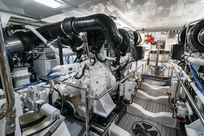 Rat Pack Yacht Photos Pics Engine room of a 2011 Marlow Explorer yacht, showcasing complex machinery and piping.