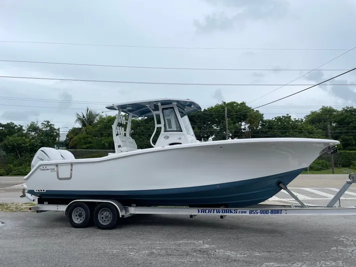  Yacht Photos Pics 2026 Tidewater 282 CC Adventure boat on trailer, parked outdoors.