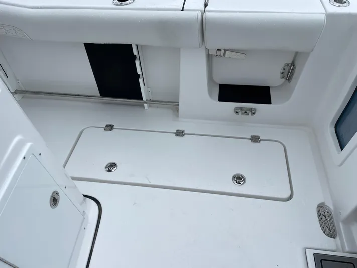  Yacht Photos Pics 2026 Tidewater 282 CC Adventure boat interior, featuring storage compartments and sleek white design.