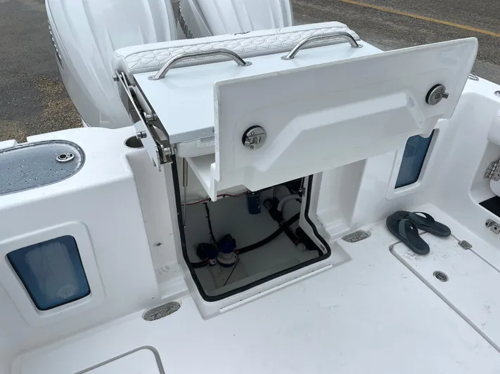  Yacht Photos Pics 2026 Tidewater 282 CC Adventure boat with open storage compartment and visible engine components.