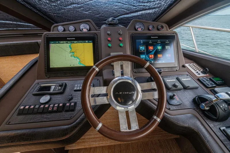 Costa Luna Yacht Photos Pics Cockpit of 2014 Azimut 64 yacht with navigation screens and steering wheel.
