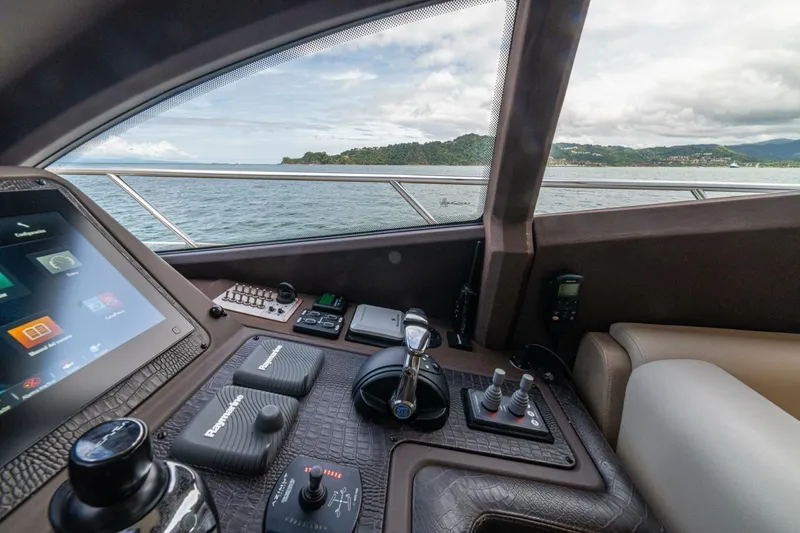 Costa Luna Yacht Photos Pics Interior view of 2014 Azimut 64 yacht cockpit with control panel and scenic ocean backdrop.