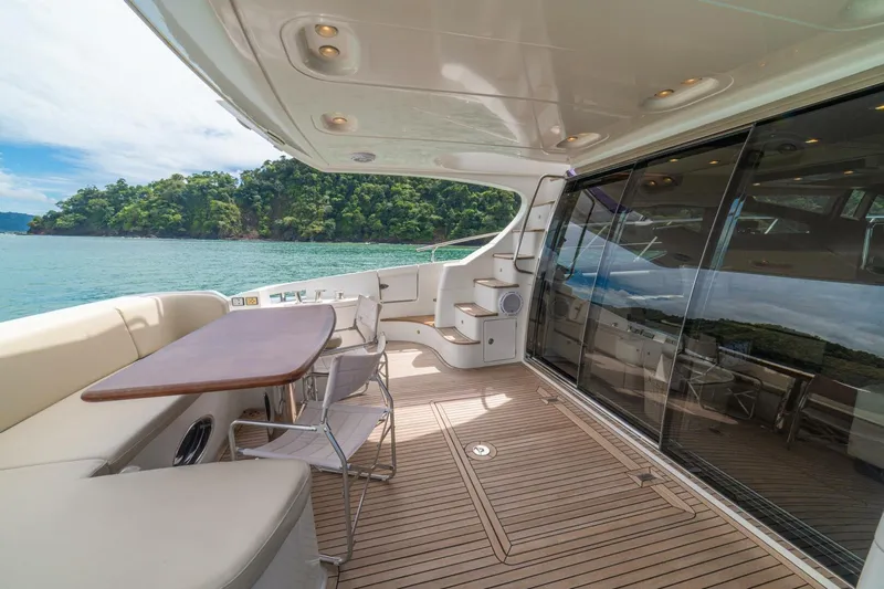 Costa Luna Yacht Photos Pics Luxurious 2014 Azimut 64 yacht deck with seating, overlooking serene waters and lush greenery.