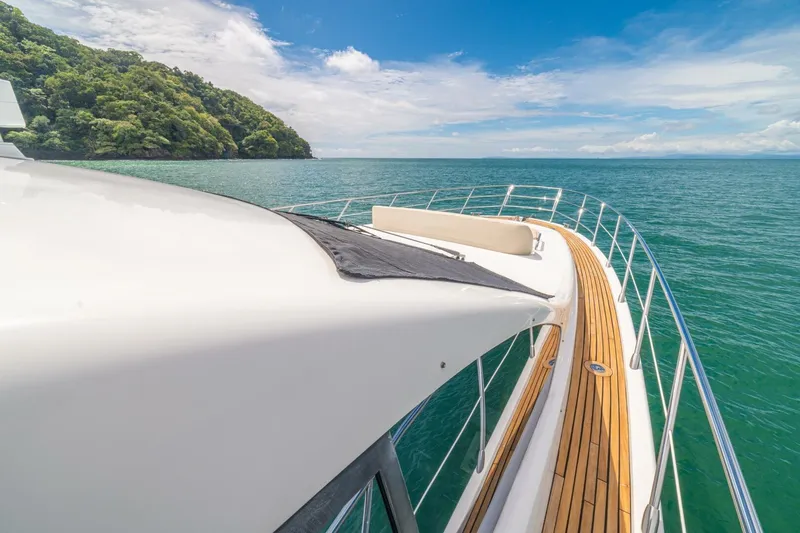 Costa Luna Yacht Photos Pics Luxurious 2014 Azimut 64 yacht cruising on serene ocean waters near lush green coastline.