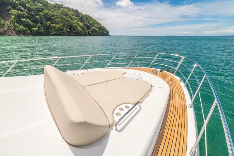 Costa Luna Yacht Photos Pics Luxurious 2014 Azimut 64 yacht deck with scenic ocean view and lush green island.