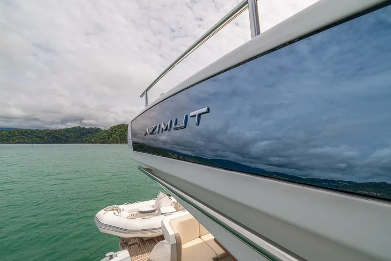 Costa Luna Yacht Photos Pics 2014 Azimut 64 yacht on serene water with lush green shoreline.