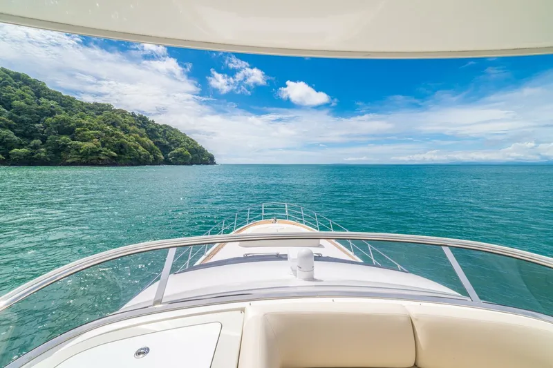 Costa Luna Yacht Photos Pics 2014 Azimut 64 yacht cruising on turquoise waters with lush green coastline.