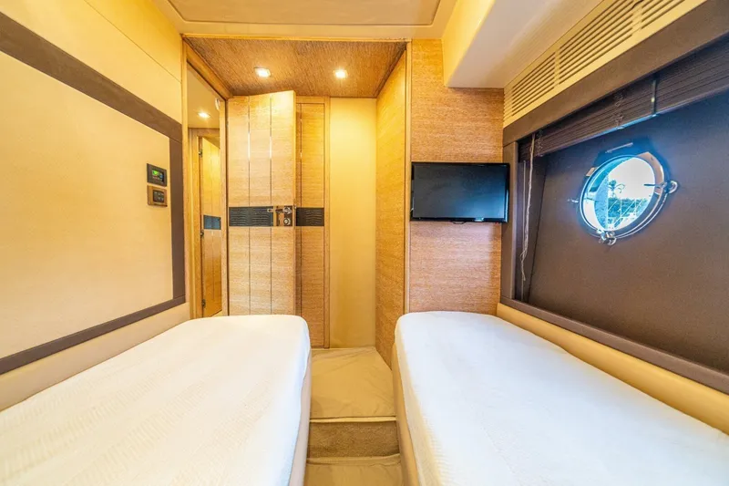 Costa Luna Yacht Photos Pics Luxurious 2014 Azimut 64 yacht cabin with twin beds, porthole, and TV.