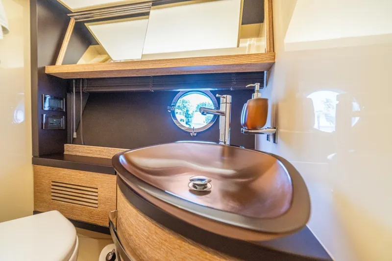 Costa Luna Yacht Photos Pics Luxurious bathroom interior of 2014 Azimut 64 yacht with modern sink and porthole window.