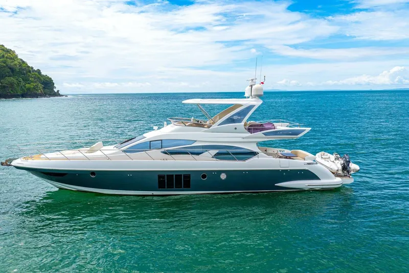 Costa Luna Yacht Photos Pics Luxurious 2014 Azimut 64 yacht cruising on serene blue waters under a clear sky.