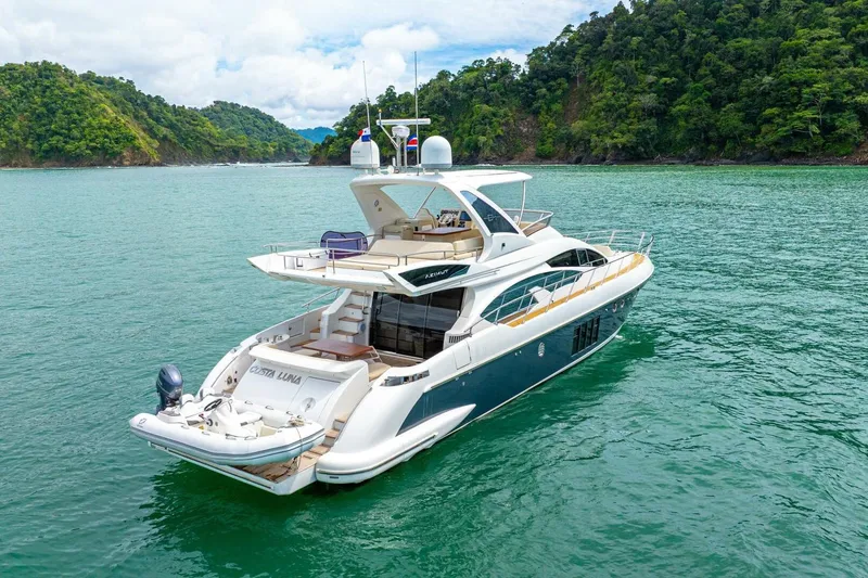 Costa Luna Yacht Photos Pics Luxurious 2014 Azimut 64 yacht cruising in tropical waters, surrounded by lush green islands.