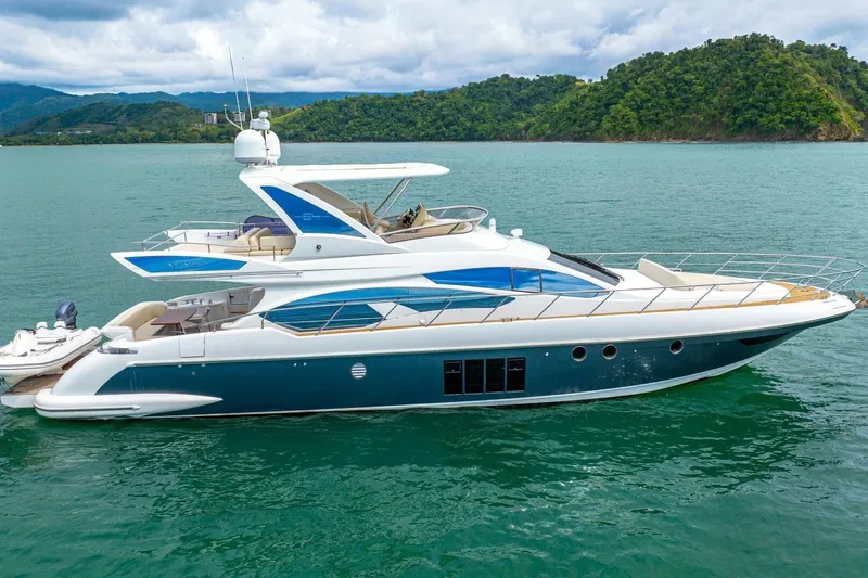 Costa Luna Yacht Photos Pics Luxurious 2014 Azimut 64 yacht cruising on serene waters with lush green hills in the background.
