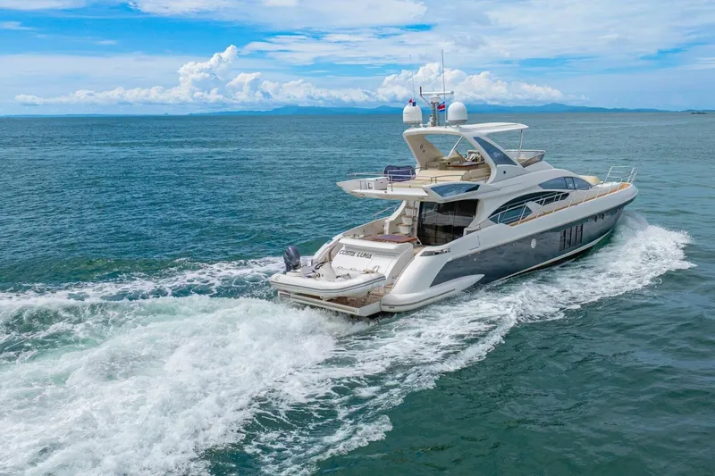 Costa Luna Yacht Photos Pics Luxurious 2014 Azimut 64 yacht cruising on open sea under clear blue skies.