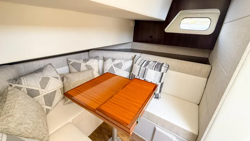Black Diamond Yacht Photos Pics 2022 Cruisers Yachts 38 GLS interior with cozy seating and wooden table.