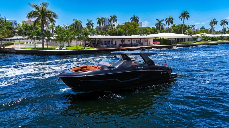 Black Diamond Yacht Photos Pics 2022 Cruisers Yachts 38 GLS on a sunny day, cruising near palm-lined waterfront.