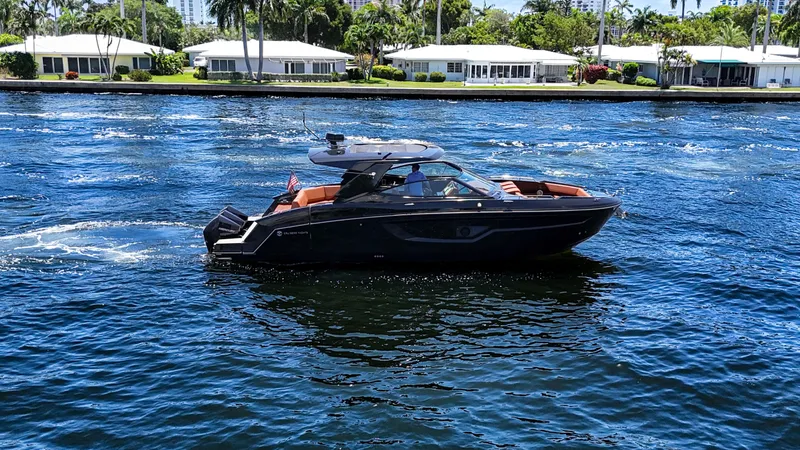 Black Diamond Yacht Photos Pics 2022 Cruisers Yachts 38 GLS on a sunny waterway, surrounded by waterfront homes.