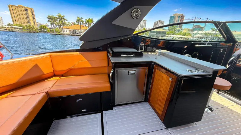 Black Diamond Yacht Photos Pics Luxurious 2022 Cruisers Yachts 38 GLS interior with seating and kitchenette by the water.