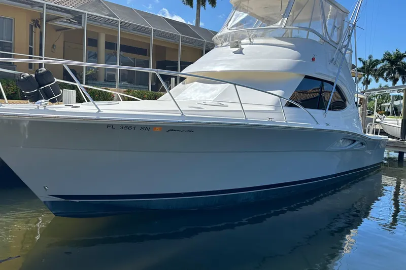 Game On Yacht Photos Pics 2002 Riviera 40 Flybridge yacht docked in sunny marina setting.