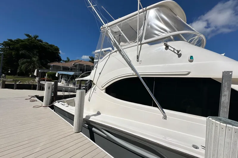 Game On Yacht Photos Pics 2002 Riviera 40 Flybridge yacht docked under clear blue sky.