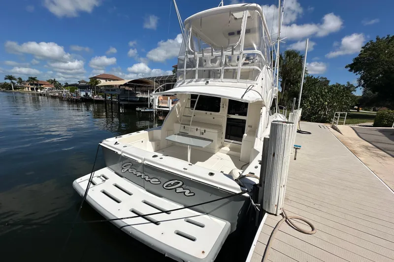 Game On Yacht Photos Pics 2002 Riviera 40 Flybridge yacht docked under a clear blue sky.